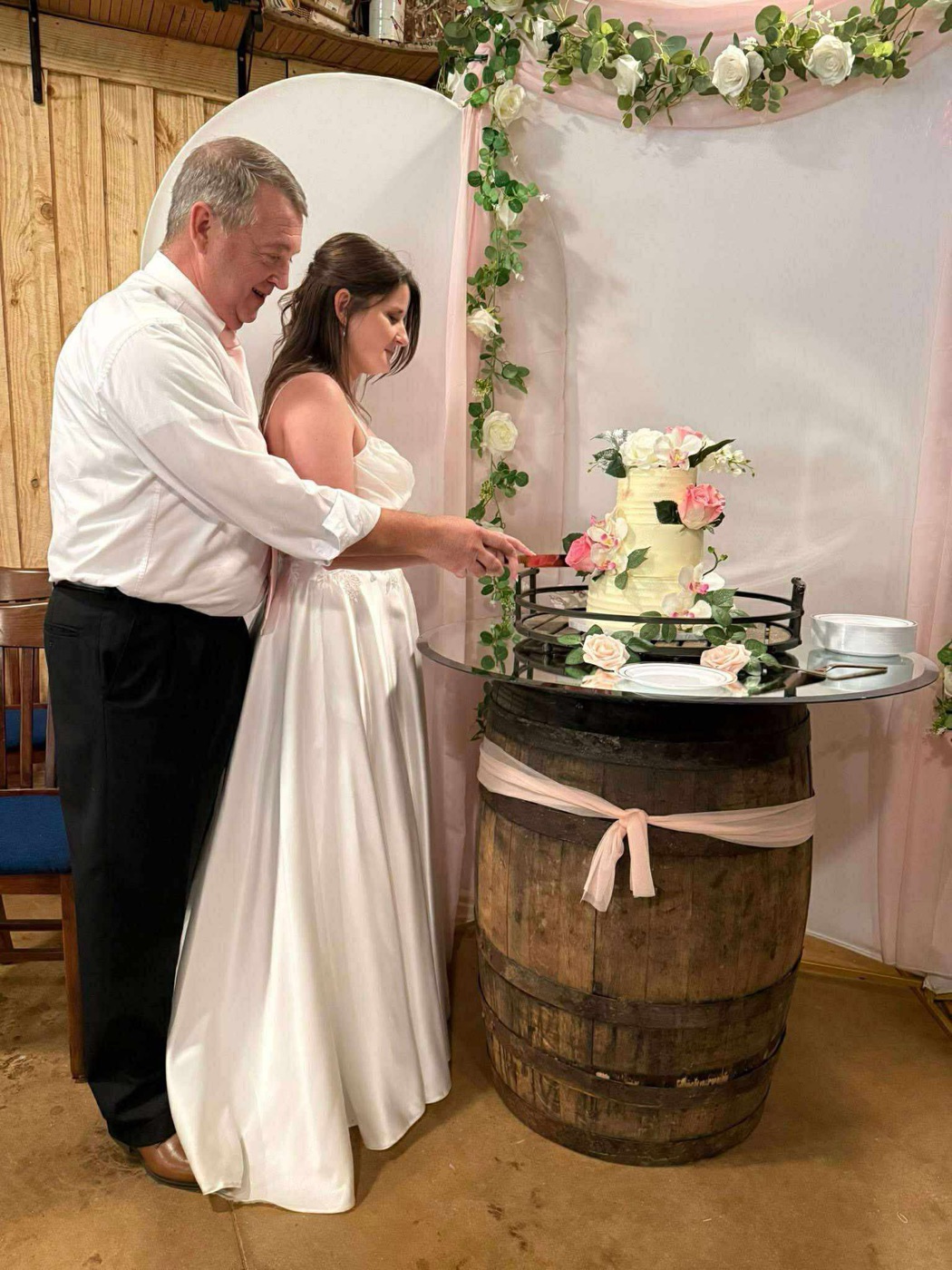 Anniversary couple cutting their cake inside The Shed at Papa's Creek