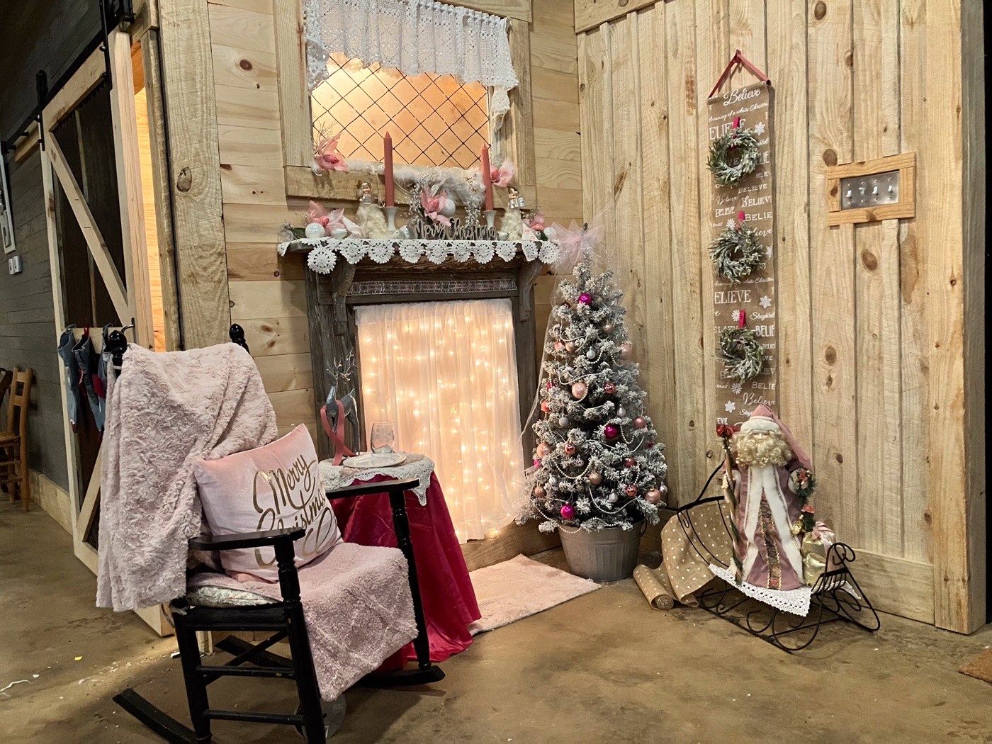 Christmas trees, stockings, and wrapped gifts arranged around The Shed fireplace