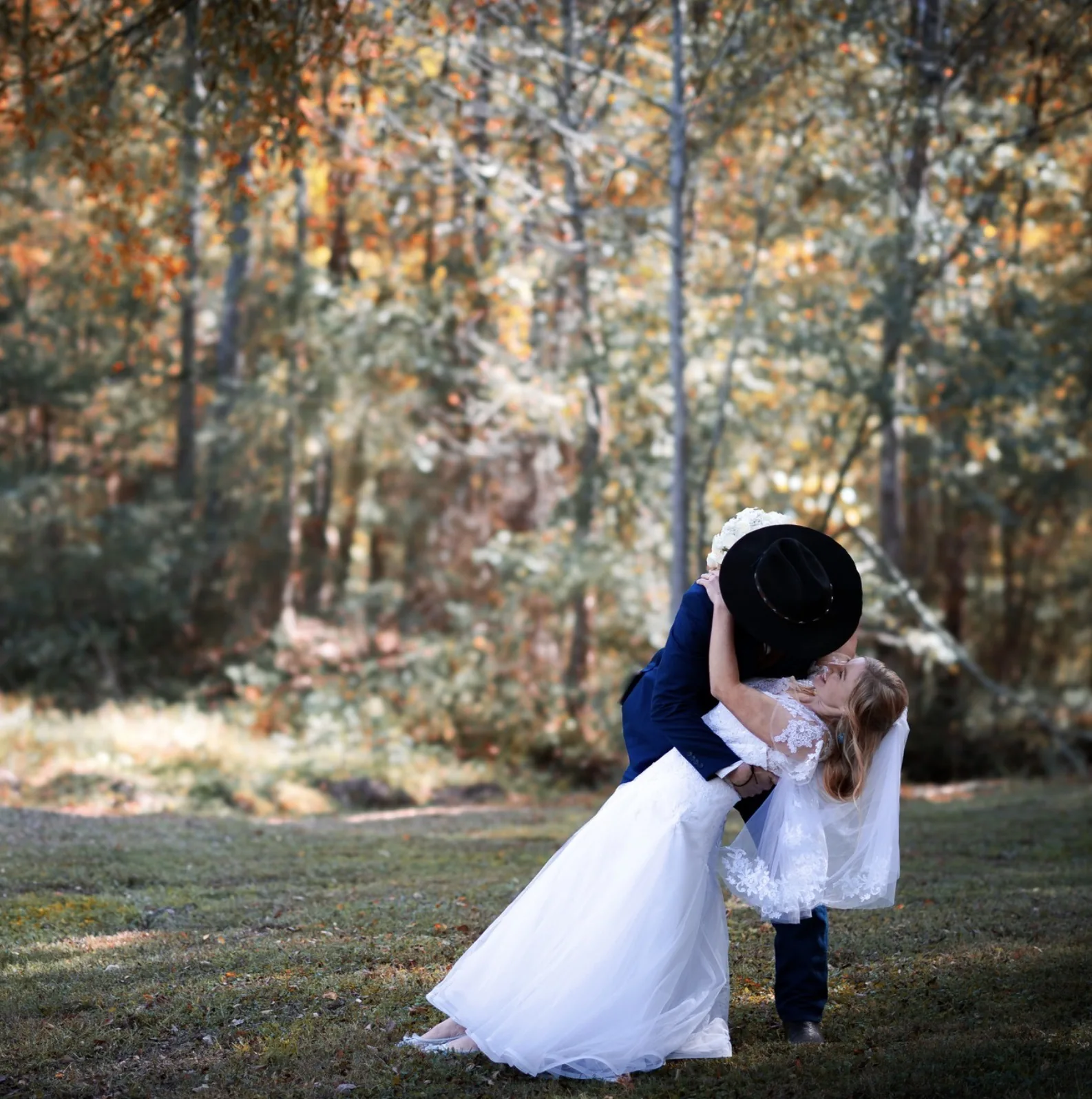 Newlyweds sharing a celebratory kiss in the woods at The Shed