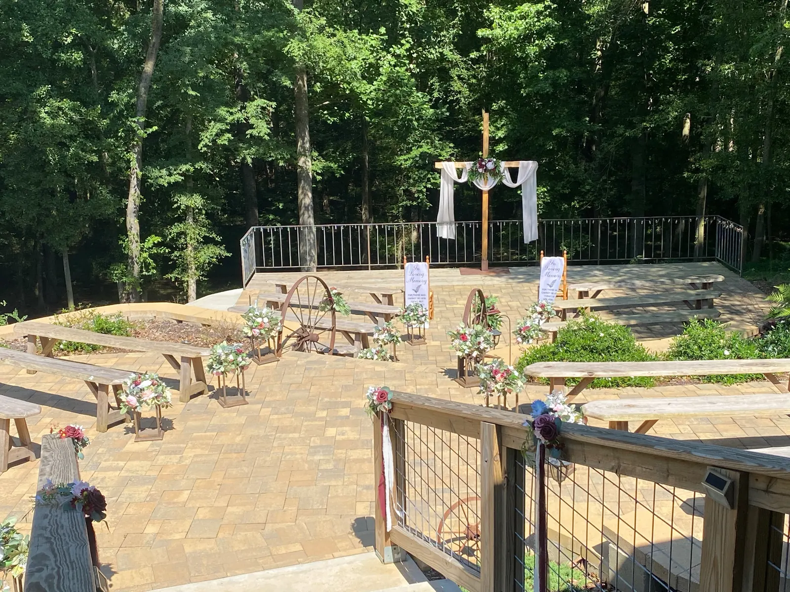 Ceremony terrace set up at The Shed at Papa's Creek – arch, benches, and wagon wheels, Lavonia Georgia