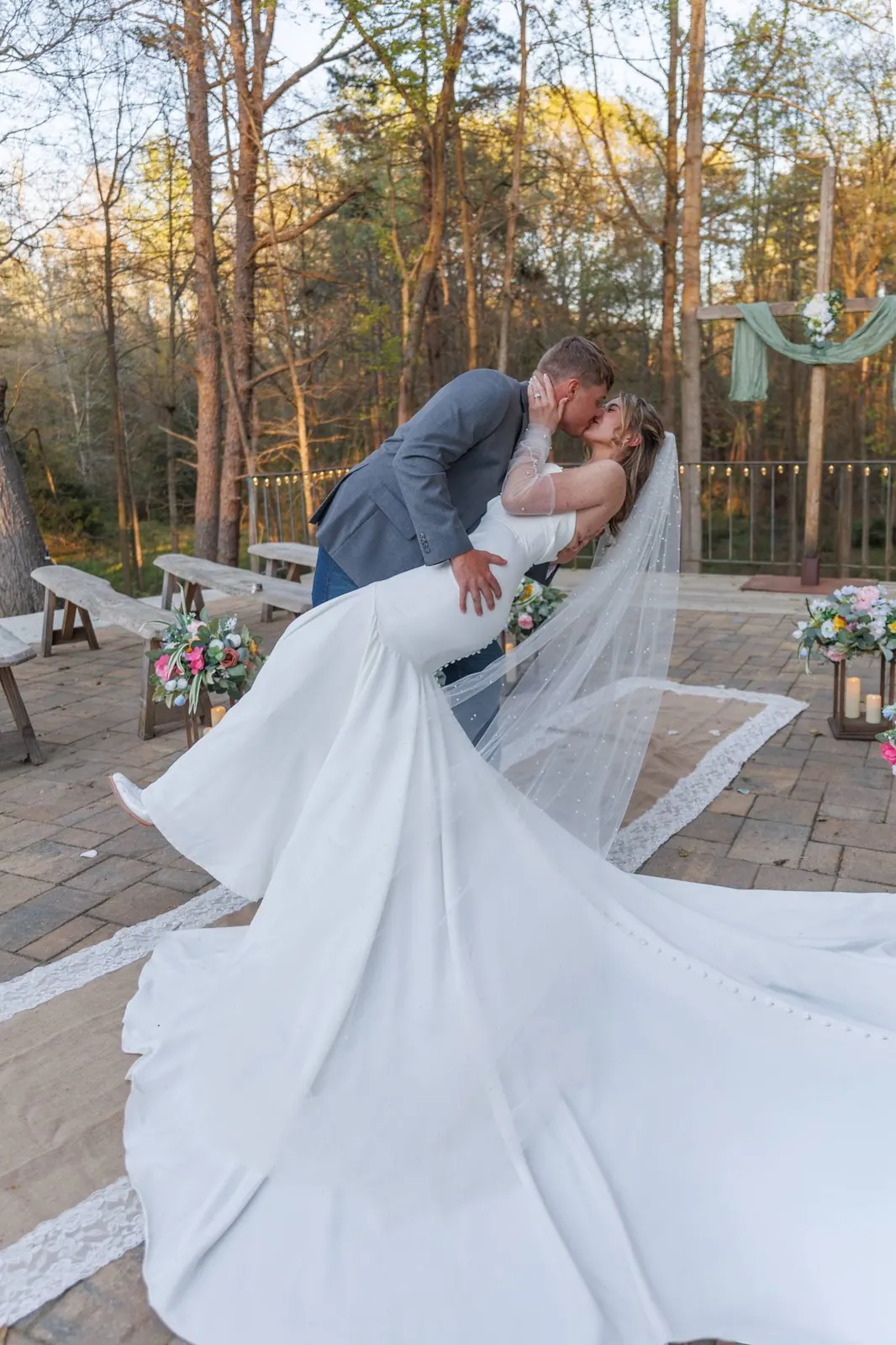 Groom dipping bride for a kiss – ceremony terrace at The Shed at Papa's Creek, veil sweeping, Lavonia Georgia
