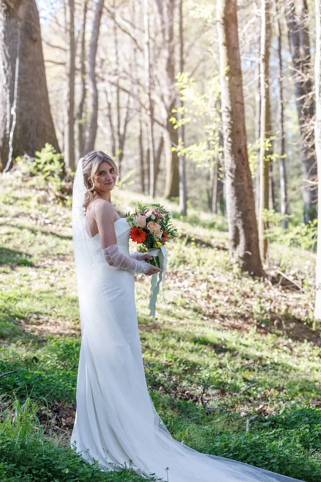 Bride looking back over shoulder in spring forest at The Shed at Papa's Creek – veil and bouquet, Lavonia Georgia