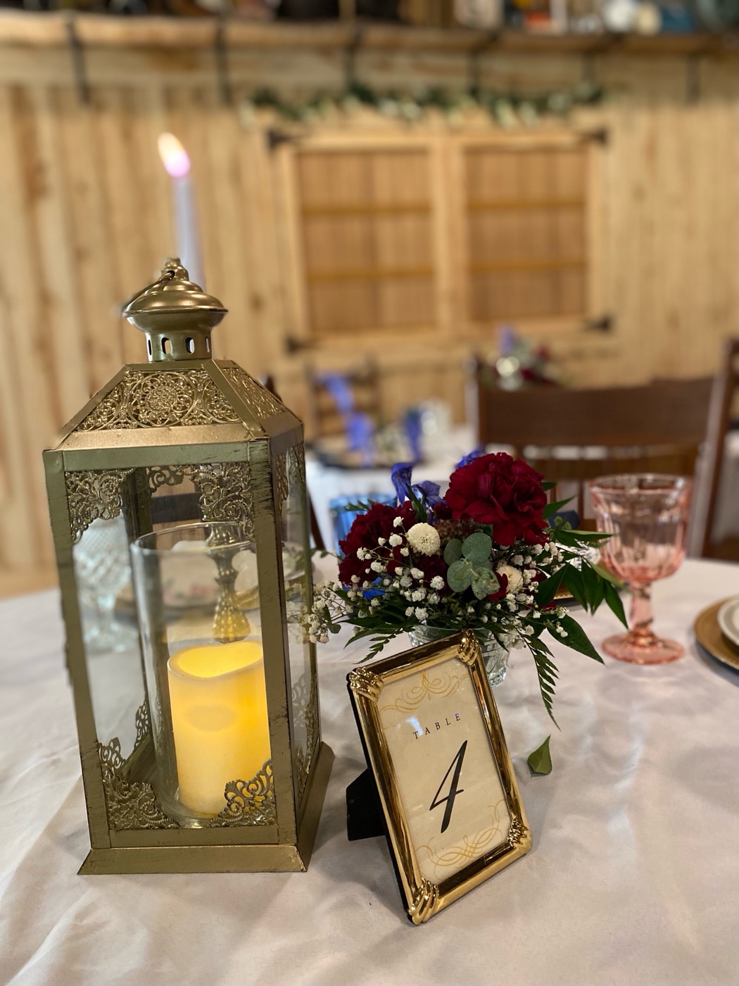 Lantern, table number, and floral centerpiece inside The Shed